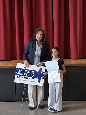 County Executive Sue Serino taking picture with honoree holding certificate and yard sign