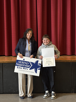 County Executive Sue Serino taking picture with honoree holding certificate and yard sign