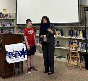 County Executive Sue Serino reading to student why they were nominated 