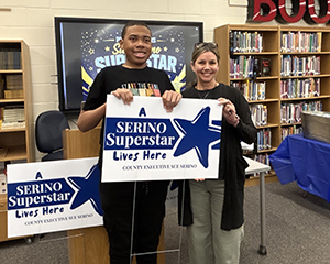 student the teacher who nominated him taking a picture with the Superstars sign
