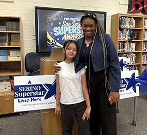 student the guidance counselor taking a picture with the Superstars sign