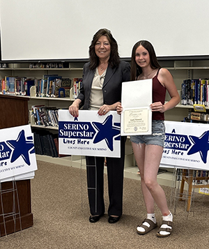 County Executive Sue Serino and taking picture with honoree with their certificate and yard sign