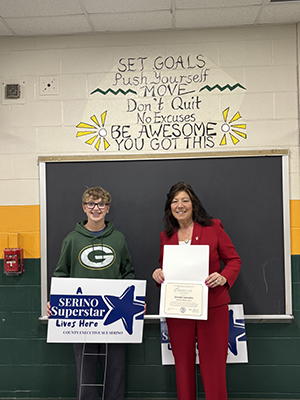 County Executive Sue Serino taking picture with honoree holding certificate and yard sign