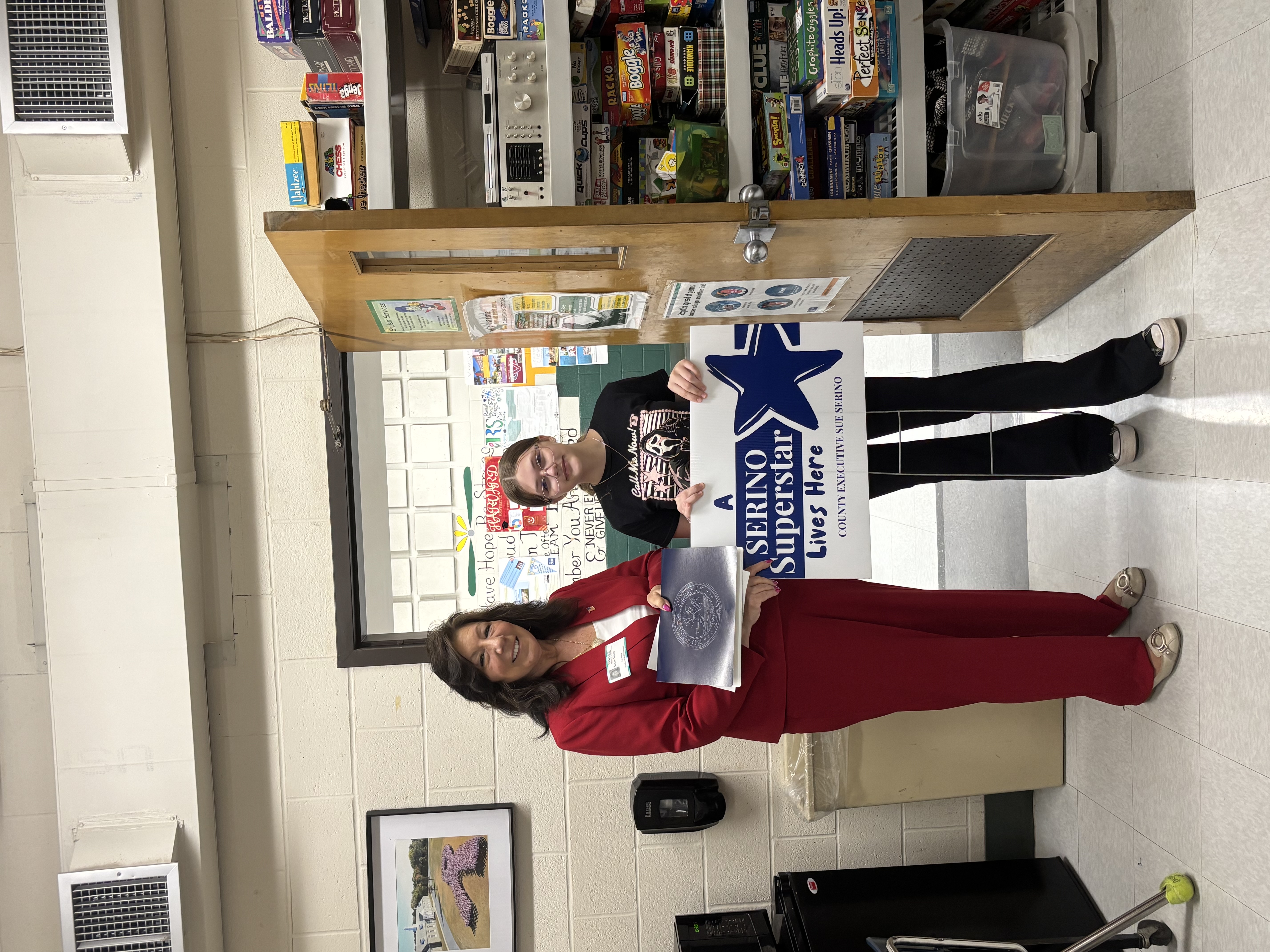 County Executive Sue Serino taking picture with honoree holding certificate and yard sign