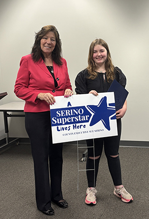 County Executive Sue Serino taking picture with honoree with their certificate and yard sign