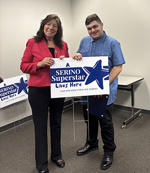 County Executive Sue Serino taking picture with honoree with their certificate and yard sign