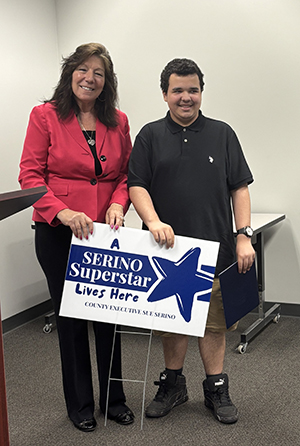 County Executive Sue Serino taking picture with honoree with their certificate and yard sign