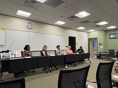 People at a conference table, speaking